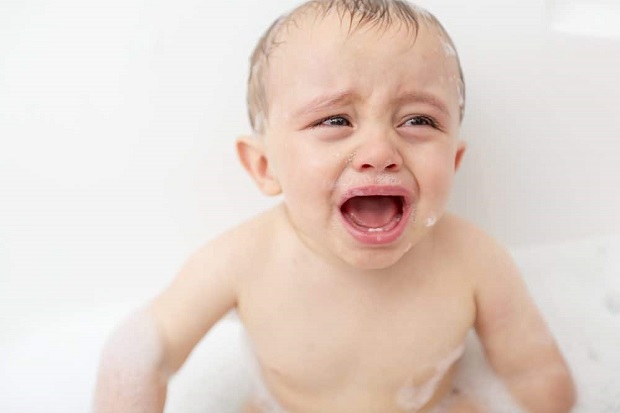 picture of a baby crying n a bath tub 