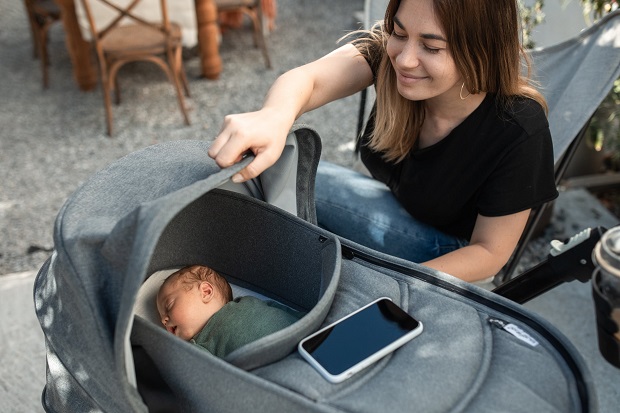 picture of a woman looking over a baby in pram outside