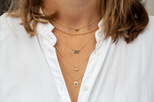 women wearing layering necklace