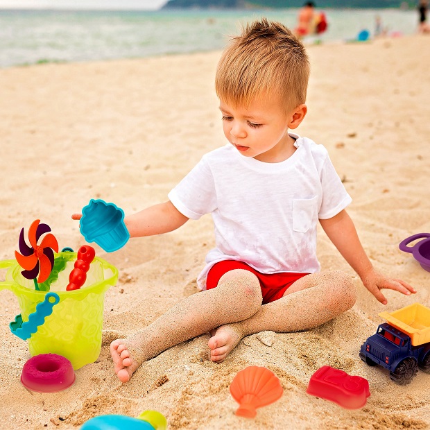 little boy with toys on the beach